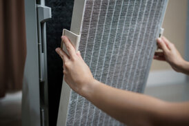 A SERVICEMASTER MOLD TECHNICIAN EXCHANGES AN HVAC FILTER FOR A CLEAN ONE AS PART OF THE MOLD REMEDIATION PROCESS